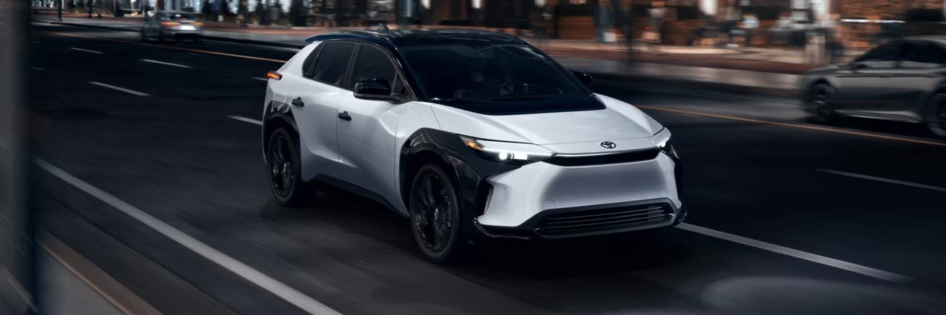 도심 도로를 주행 중인 흰색과 검은색 투톤 SUV 차량