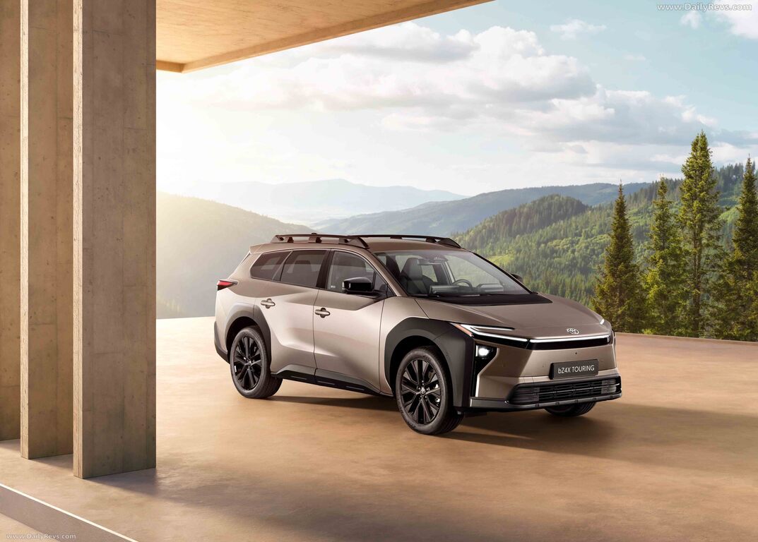 산과 숲 배경의 넓은 테라스 위에 주차된 은색 SUV 차량